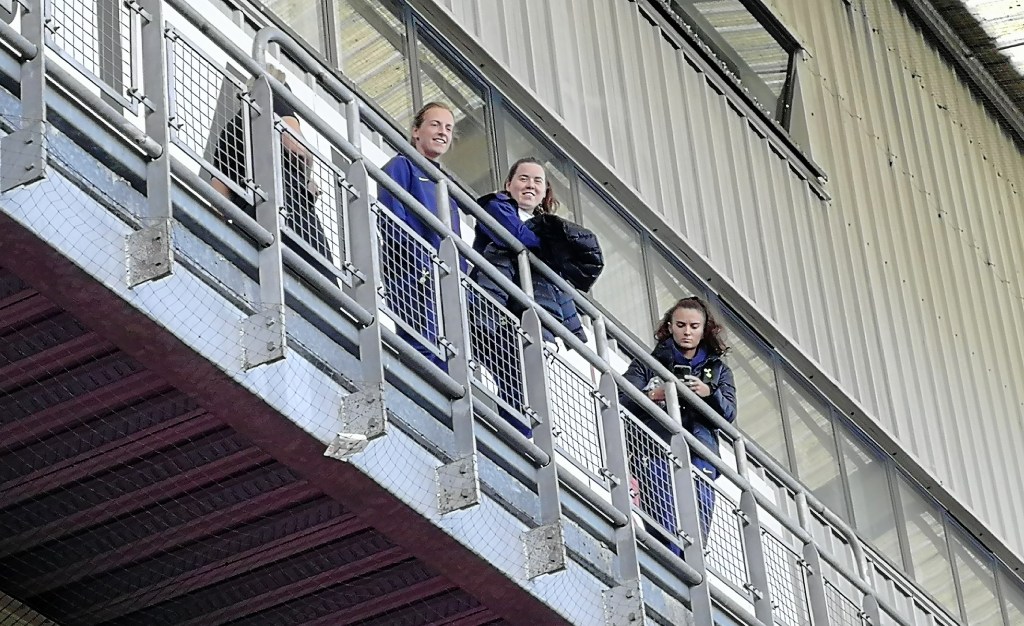 Spurs injured players looking out over the pitch at Brisbane Road